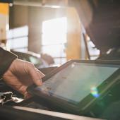 Inspektionsintervalle – was bedeutet regelmäßig? Mitarbeiter beim Motorcheck mit Tablet